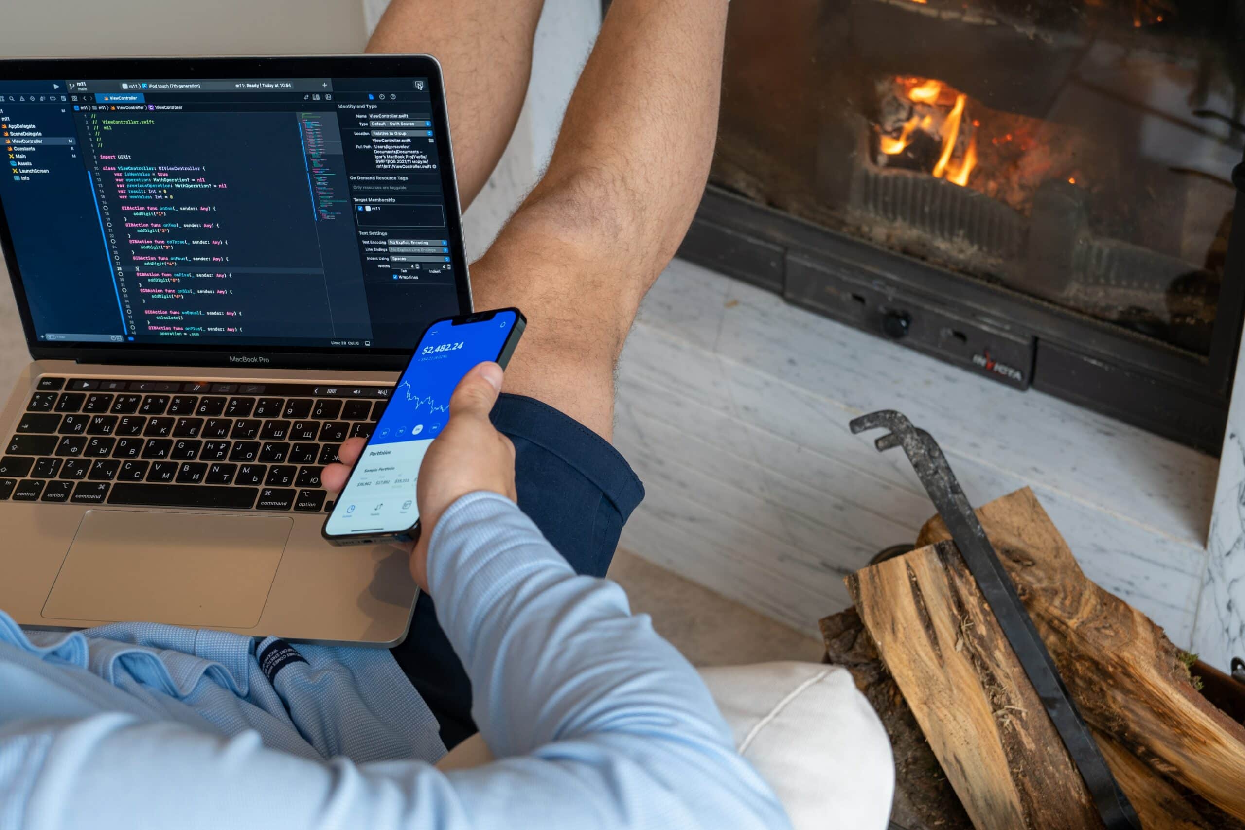 Man on couch in front of fire as he works from home because he does freelance software development and thinks it is worth it